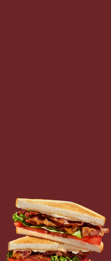 BLT sandwich stack on a dark red background