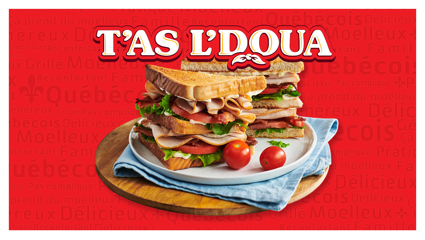 Stacked sandwich on a plate with tomatoes on a red background featuring 'T'AS L'DOUA'.